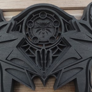 Puede incluir: Decoración de pared de madera negra con una talla detallada de una cabeza de lobo y un diseño circular con un símbolo de lobo en el centro.