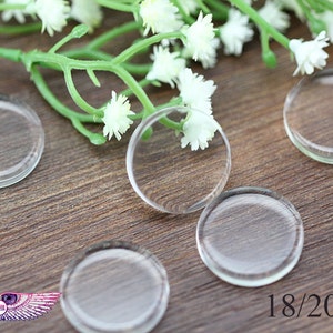May include: Five clear glass circles, each measuring 18/20 mm in diameter, are arranged on a wooden surface. The circles are slightly raised from the surface and have a smooth, polished finish.