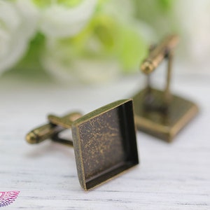 May include: A pair of antique gold cufflinks with square glass inserts. The cufflinks have a distressed finish.