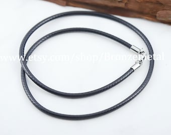 May include: A black braided leather cord necklace with silver-toned clasps. The cord is approximately 2mm thick.