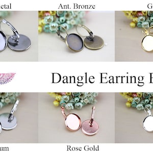 Puede incluir: Bases de pendientes colgantes en gunmetal, bronce antiguo, oro, platino, oro rosa y plata. Cada base tiene un engaste redondo y un cierre de palanca. Se muestra el texto "Dangle Earring Base".