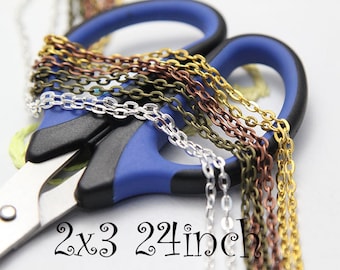 May include: Six strands of chain in silver, gold, copper, and bronze colors, each 24 inches long, are laid out on a blue pair of scissors. The text "2x3 24 inch" is written below the chains.