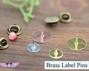 Puede incluir: Un conjunto de alfileres para etiquetas de latón con una variedad de acabados, que incluyen oro, plata y cobre. Los alfileres están diseñados para sujetar etiquetas a los artículos.