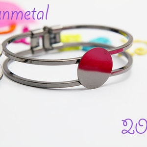 May include: Gunmetal bracelet with a 20mm round bezel for adding a charm or embellishment. The bracelet is double-layered and has a hinged clasp.