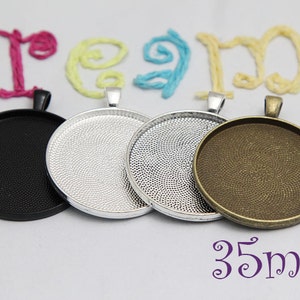 May include: Four round pendant trays in black, silver, and bronze tones. The trays are 35mm in diameter and have a textured surface. The word "dream" is spelled out in colorful yarn above the trays.