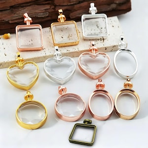 May include: A selection of clear glass and metal pendant blanks in diverse shapes, including square, heart, oval, and round. The metal frames are in gold, silver, and rose gold finishes. These pendants are for jewellery making and crafting.