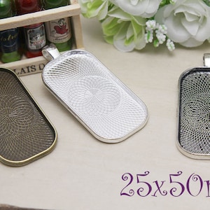 Puede incluir: Tres bandejas de colgante plateadas con un patrón decorativo. Las bandejas son rectangulares y miden 25 x 50 mm.