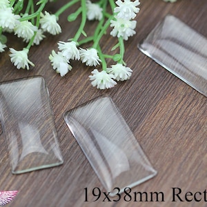 以下が含まれることがあります： 木製の表面に、19 x 38 mm の透明なガラス製の長方形のcabochonsが3つあります。