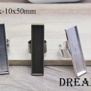 May include: Three rectangular ring blanks in silver, bronze, and gunmetal colors. Each blank measures 10mm x 50mm. The word "DREAM" is printed in black at the bottom. The text "Blank-10x50mm" is printed at the top.