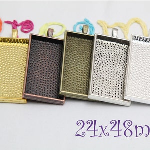 May include: Five rectangular metal pendant trays in gold, bronze, antique brass, silver, and white silver. Each tray measures 24x48mm and has a textured surface.