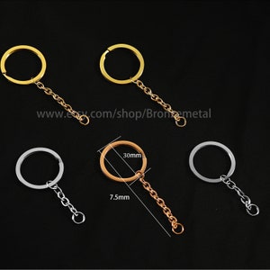 May include: Three keychains with different colored rings and chains. The keychain on the left has a silver ring and chain. The keychain in the middle has a gold ring and chain. The keychain on the right has a silver ring and chain. The keychain in the middle has a 30mm ring and a 7.5mm chain.