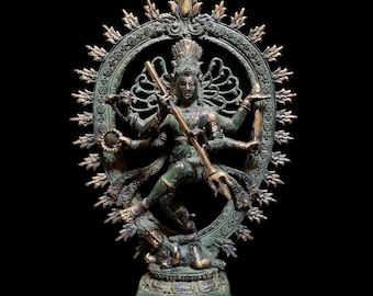 May include: A bronze statue of a multi-armed deity, possibly Shiva, in a dynamic dancing pose. The figure is surrounded by a circular halo with radiating points. The statue has intricate details and is set against a black background.