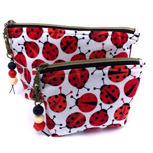 Ladybug Cosmetic Bag, Fully Lined, Lightly Padded. Red & Black Ladybugs on White, Zipper Close with Beaded Zipper Pull. 2 Sizes Available.