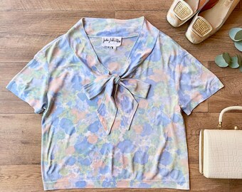 Blusa vintage de los años 60 de John J Hilton, modelo Arnel con estampado floral en acuarela y lazo, talla mediana.