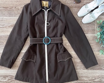 Chaqueta marrón estilo Mod vintage de los años 60 con cinturón y cremallera frontal con costuras en contraste, talla mediana.