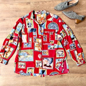 Può includere: Una camicia a maniche lunghe abbottonata di colore rosso vivace, caratterizzata da un collage ripetitivo di varie illustrazioni artistiche e dipinti all'interno di cornici rettangolari. La camicia presenta un colletto classico, due tasche sul petto e polsini con bottoni.