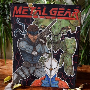 May include: A wooden plaque featuring artwork from the video game Metal Gear Solid. The artwork depicts characters in a comic book style, with the game's title in red at the top. The characters are in shades of blue, green, and orange against a black background.