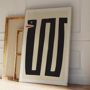 May include: Abstract art print featuring a black and white geometric design of a snake with a red mouth. The print is framed in a gold frame and is hanging on a white wall.