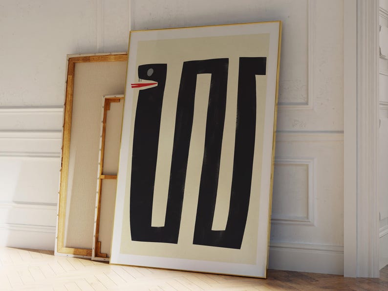 May include: Abstract art print featuring a black and white geometric design of a snake with a red mouth. The print is framed in a gold frame and is hanging on a white wall.