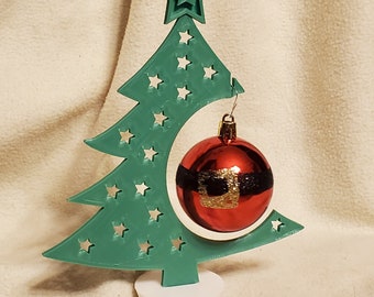May include: A green 3D printed Christmas tree ornament holder with a star on top and a red ornament hanging from it.