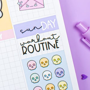 May include: A planner page with skull stickers in various colors, a light blue skull sticker, and the words "Sunday workout ROUTINE." A purple pen and decorative shapes are also visible.