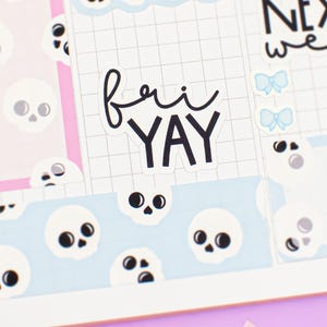 Peut inclure: Une page de planificateur avec un motif quadrillé, présentant des illustrations de crânes et de nœuds en bleu clair et rose. Le texte "fri YAY" est affiché en script noir. Les mots "NEXT week" sont également visibles.