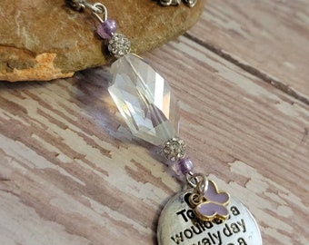 May include: A silver necklace with a crystal pendant and a charm that says "Today would be a lovely day to be a butterfly". The charm has a small purple butterfly attached to it.
