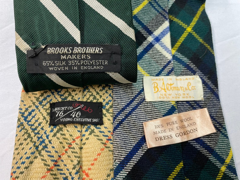 Pode incluir: Quatro gravatas com padr&otilde;es e etiquetas diferentes. As etiquetas incluem Brooks Brothers Makers, B. Altman & Co., Hecht Co. e Dress Gordon. As gravatas s&atilde;o feitas de seda, poli&eacute;ster e l&atilde;.