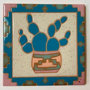 May include: A blue and green ceramic tile with a geometric design. The tile features a stylized cactus plant in a pot with a pink, green, and brown pattern.