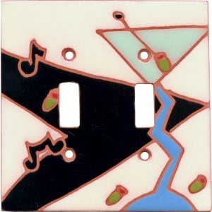 May include: A white ceramic light switch cover with a colorful abstract design featuring a martini glass, musical notes, and green olives. The design is in shades of black, blue, green, and red.