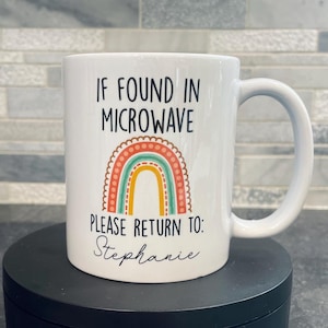 May include: White ceramic mug with a rainbow design and the text "IF FOUND IN MICROWAVE PLEASE RETURN TO: Stephanie".