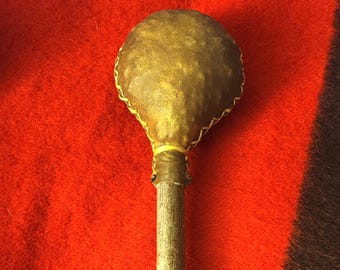 Indiaanse rammelaar van ongelooide huid: handvat van elzenhout, gevuld met zaden