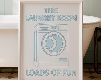 May include: A framed print with the text "THE LAUNDRY ROOM LOADS OF FUN" and a blue illustration of a washing machine. The print is in a bathroom with a clawfoot tub and floral wallpaper.
