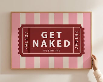 May include: Framed art print with a pink and white striped background. A burgundy ticket-shaped design in the center reads "GET NAKED" in white text, with "IT'S BATH TIME" below. The frame is a light wood color.