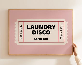 May include: A pink framed print with a white ticket design that says "Laundry Disco" with the number "701406" on each side and the words "Admit One" in the center.