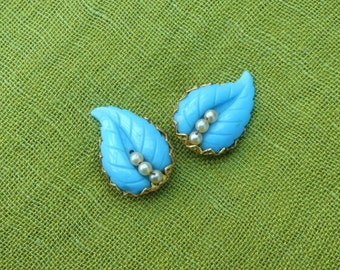 Par de broches vintage de los años 40, a juego, de celuloide azul turquesa y perlas de imitación, con forma de hoja y reverso de filigrana dorada.