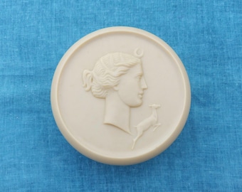 Polvo de celuloide vintage de la década de 1930 con Diana la Cazadora en la tapa, diosa griega de la luna con un ciervo saltando, época art déco.