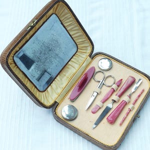 Set da manicure vintage anni &#39;40/&#39;50 in scatola di pelle effetto pelle di serpente marrone chiaro con set di 8 utensili in celluloide marmorizzata rossa e crema