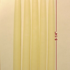 May include: Five ivory-colored taper candles, each approximately 9-1/4 inches tall and 3/4 inch in diameter. The candles are arranged vertically against a neutral background, showcasing their smooth, cylindrical shape and wick.