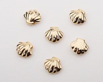 May include: Six gold-tone seashell charms with clear rhinestone accents.