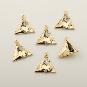 May include: Six gold triangle charms with clear rhinestones. The charms have a textured surface and are perfect for jewelry making.
