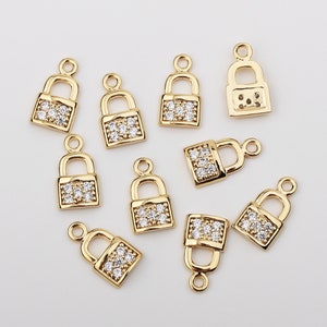 May include: Ten gold-tone padlock charms with clear crystal accents. The charms are approximately 1 inch in size.