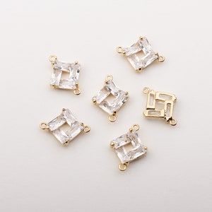 May include: Six gold-tone metal connector charms featuring clear cubic zirconia stones. The charms are square shaped with a hole on each side for attaching to jewellery.