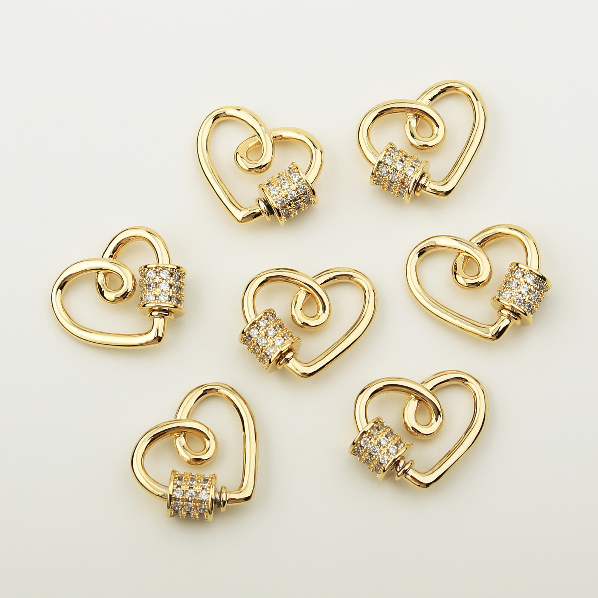 May include: Six gold heart-shaped clasps with clear rhinestone accents. Each clasp has a swiveling ring.