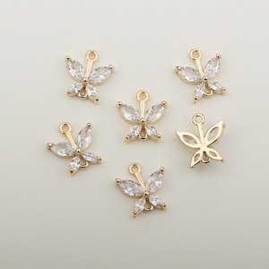 May include: Gold-colored butterfly charms with clear, sparkling crystal accents. The charms have a loop at the top for easy attachment to jewelry. The butterfly wings are made of marquise-cut crystals.
