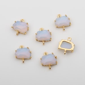 May include: Six gold-tone metal charms with a white opal-like stone. Each charm has a loop at the top for attaching to a necklace or bracelet.