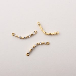 May include: Three gold-toned connector chains with clear crystal accents. Each chain has two loops at the ends.