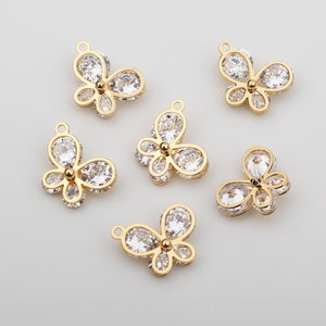 May include: Six gold butterfly charms with clear crystal accents. The charms are perfect for jewelry making or adding a touch of sparkle to crafts.
