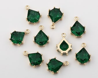 May include: A set of eight gold-toned pendant charms featuring green faceted glass stones. Each charm has a loop at the top for attaching to a necklace or bracelet.