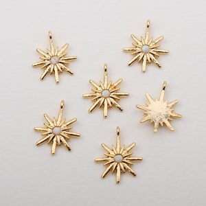 以下が含まれることがあります： 虹色の白いオパールの中心を持つ、金色の星型のチャーム6個。チャームはテクスチャ加工された表面を持っており、ジュエリー作りに最適です。
